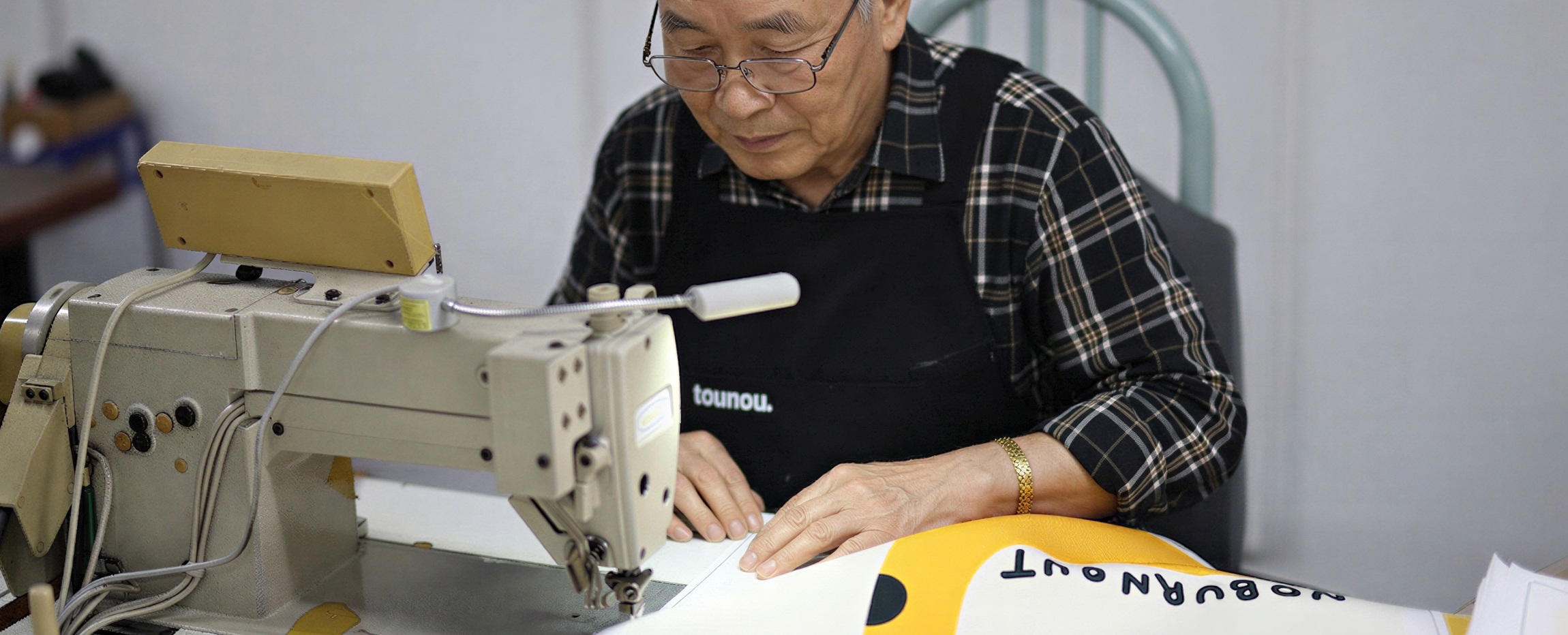 완성된 패브릭 원단을 바탕으로 오래된 숙련자가 봉제 작업을 하며 원단 상태를 재체크 하는 장면